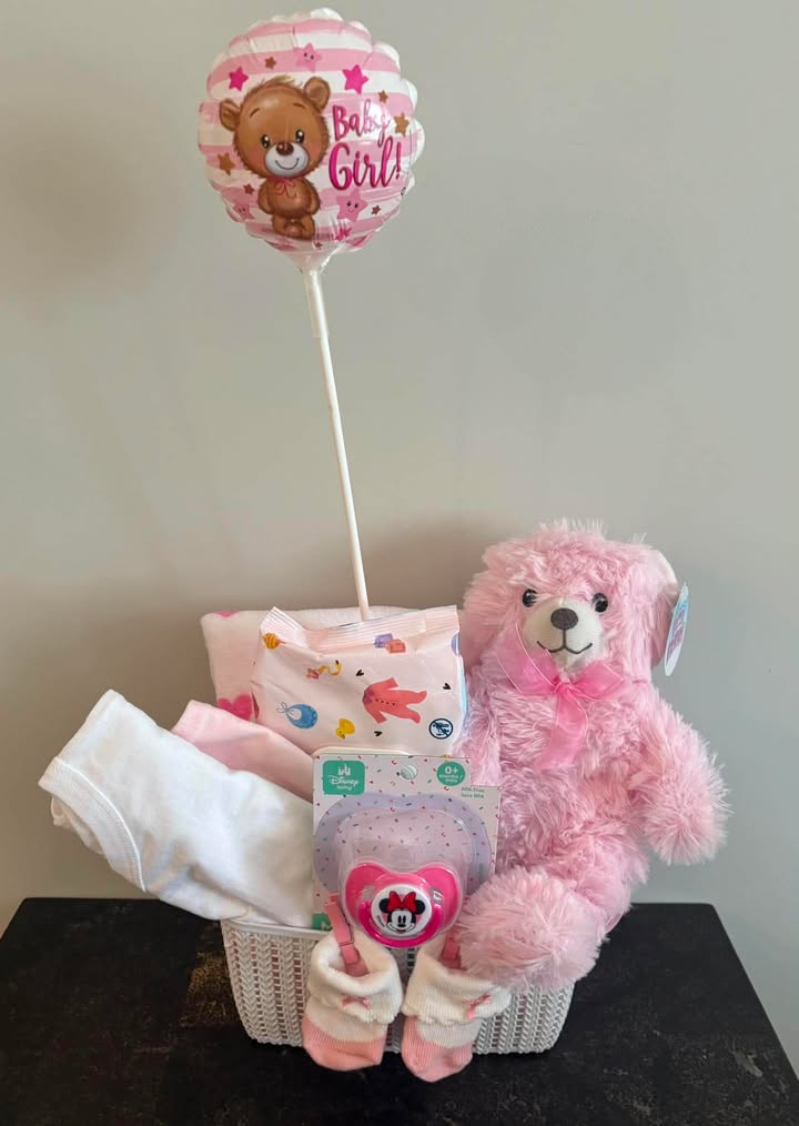 Baby girl basket with teddy bear, balloon, pacifier, socks, and clothing